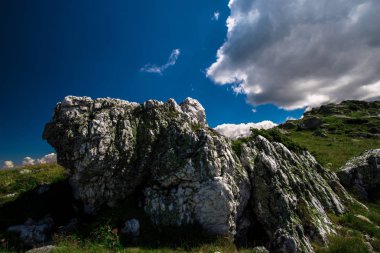 Güneşli havalarda dağın tepesinde kayalar