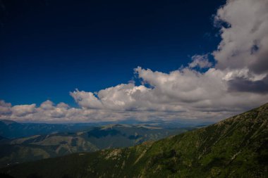 Arka plan beyaz bulutlar ve mavi gökyüzü ile yüksek Dağları