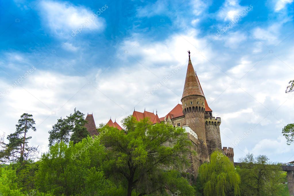 medieval Corvinesti Castle and blue sky with clouds, Romania 