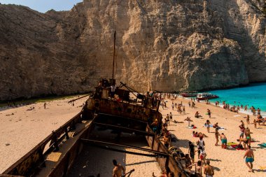 İnsanlar eski terk edilmiş gemi, Yunanistan ile plajda dinlenme.
