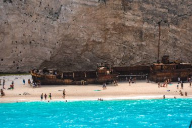 İnsanlar eski terk edilmiş gemi, Yunanistan ile plajda dinlenme.