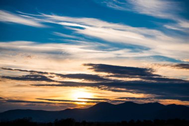 Günbatımı güneş ve bulutlar gizleme ile alanında