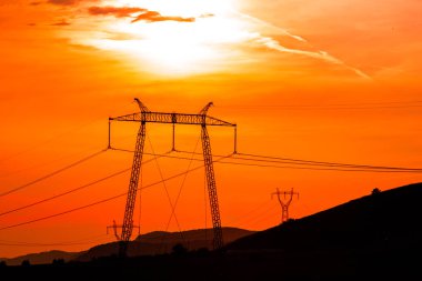 Elektrik direkleri ve günbatımı gökyüzü parlak manzara