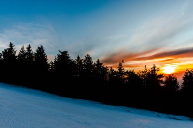 karda günbatımı gökyüzü akşam dağlar ağaçları ile kaplı 