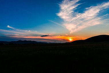 sahne günbatımı gökyüzü ufukta bulutlar ve tepeler manzara ile 