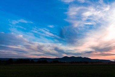 Beyaz bulutların üzerinde manzara çayır alan Hills ile mavi gökyüzü 