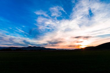 bulutların üzerinde manzara çayır alan Hills ile mavi günbatımı gökyüzü