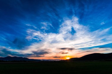 bulutların üzerinde manzara çayır alan Hills ile mavi günbatımı gökyüzü