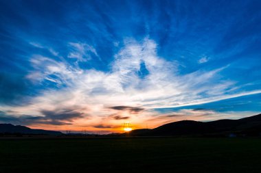 bulutların üzerinde manzara çayır alan Hills ile mavi günbatımı gökyüzü