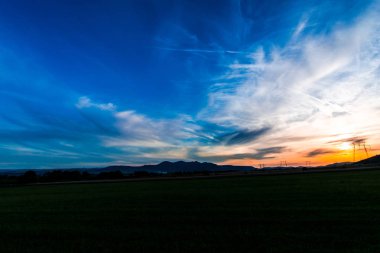 bulutların üzerinde manzara çayır alan Hills ile mavi günbatımı gökyüzü