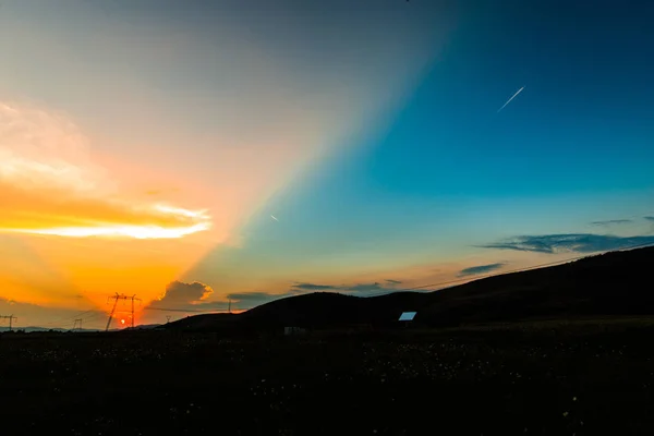 太陽と雲を非表示のフィールドのカラフルな夕日 — ストック写真