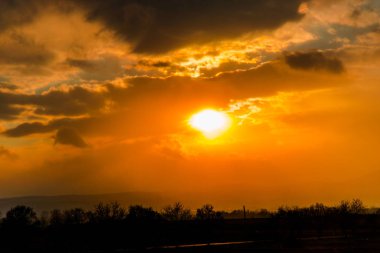 Güneşin ve bulutların gizleme ile alanında renkli günbatımı