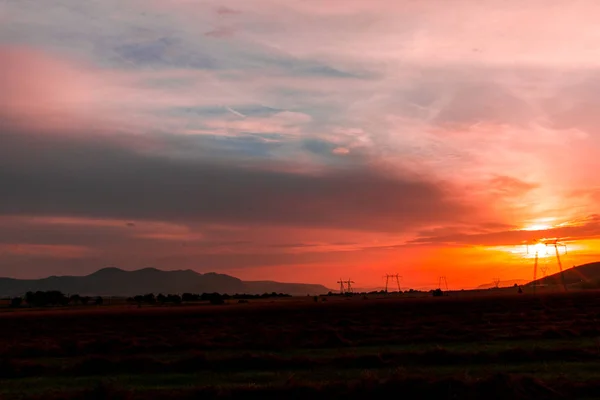 Malowniczy Widok Zachód Słońca Dziedzinie Ukrywanie Kolorowe Chmury Słońce — Zdjęcie stockowe