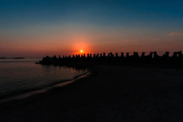 Dalgakıran Bloklarla Okyanusu Günbatımı Gökyüzünde Kırmızı Güneş — Stok fotoğraf