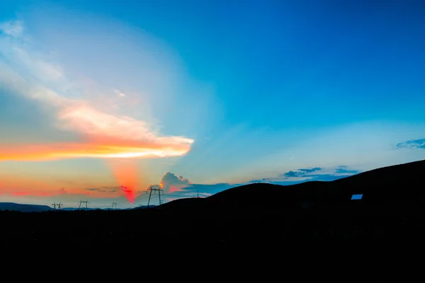 太陽とカラフルな雲を非表示フィールドに夕暮れ時の美しい景色 — ストック写真