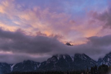 Görkemli Mor günbatımı veya gündoğumu gökyüzü bulutlu Dağları yukarıda 