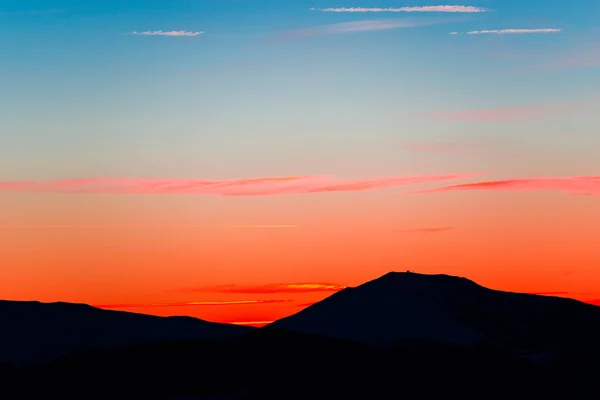 Black mountains silhouettes with bright sunset sky background