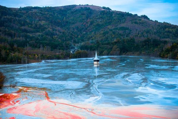 Landscape of flooded church in toxic polluted lake due to copper mining
