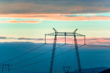 kabloları ile günbatımı gökyüzü ve gerilim direkleri