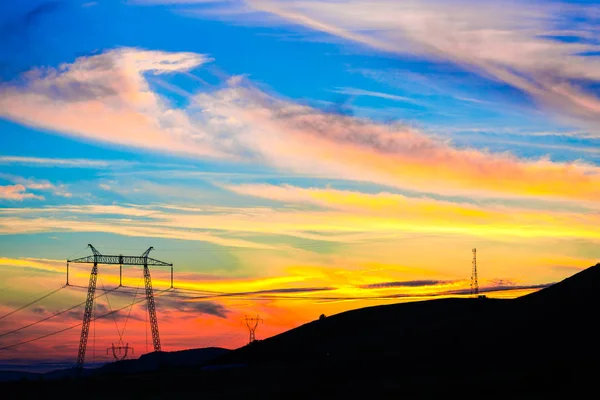 bright colorful blue orange sunset in sky and electric poles