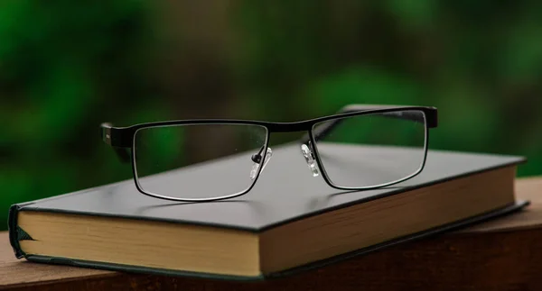 Closed book with eyeglasses