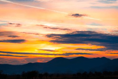 turuncu günbatımı gökyüzü bulutlu ve kırsal manzara hills ile akşam 