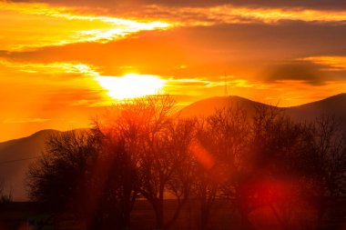parlak turuncu günbatımı gökyüzü bulutlar ve manzara ile 
