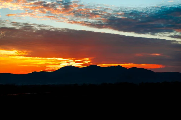 colorful sunset sky and mountains silhouette on horizon