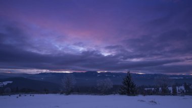 ağaçlar ve koyu mor gökyüzü ile dağlarda kış 