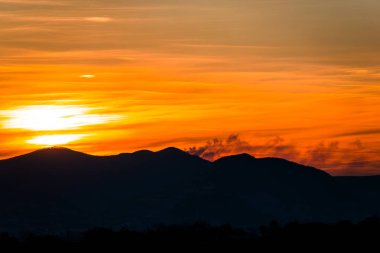 görkemli günbatımı gökyüzü ve güneş, dağlar siluet ufuk üzerinde  