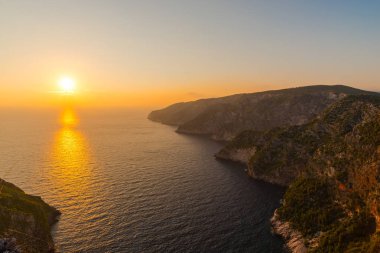 Günbatımı zamanında Yunanistan 'da Akdeniz ile kayalık uçurum.