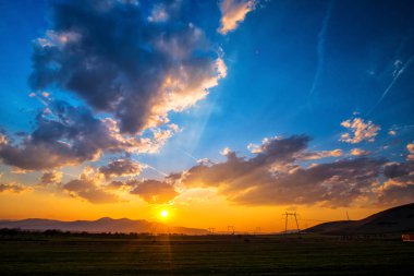 bulutlu gökyüzü günbatımı ve elektrik direkleri kuleleri