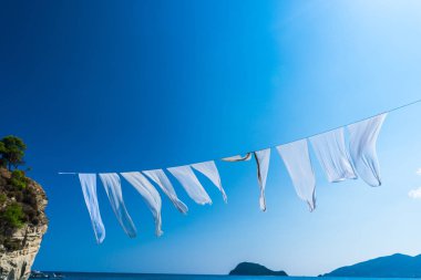 Beyaz sallayarak perdeler doğal arka planda iplik hattı üzerinde kurutma