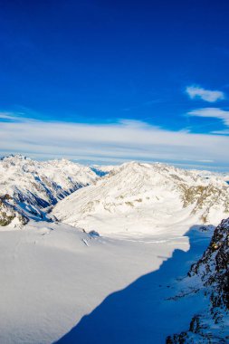 mavi gökyüzü bulutlu içinde kar dağların kaplı