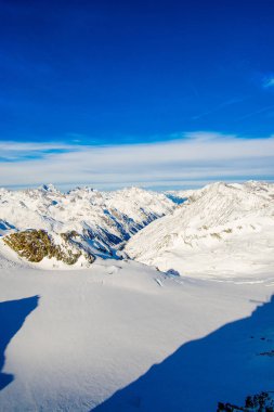 mavi gökyüzü bulutlu içinde kar dağların kaplı