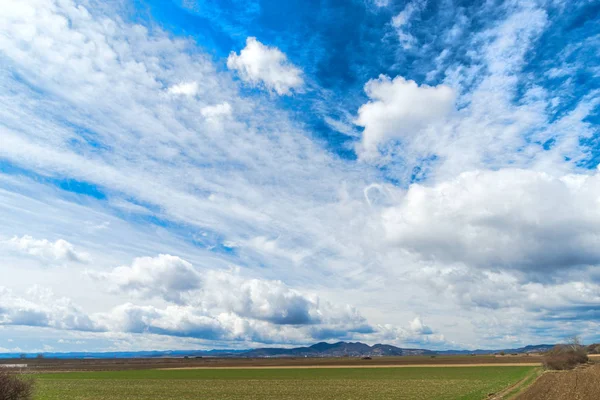 sky with white clouds and countryside landscape