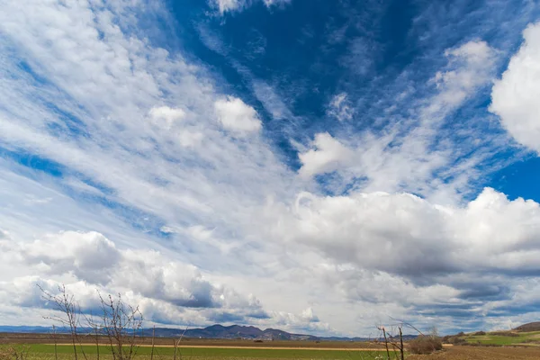 sky with white clouds and countryside landscape