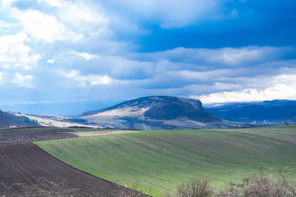 Blue sky with cirrus white clouds and countryside landscape with hills