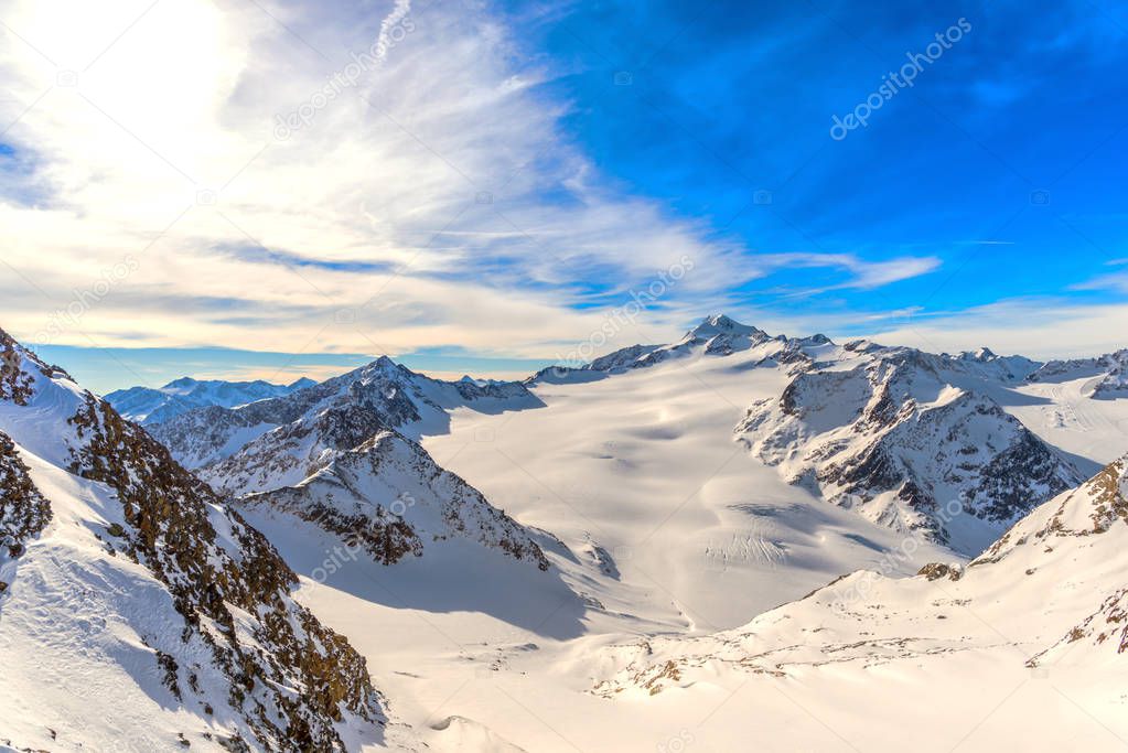 blue sky with clouds in snow covered mountains in winter 