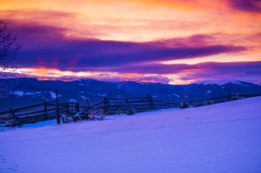 Alacakaranlıkta, kış manzarası inanılmaz karlı dağlar.