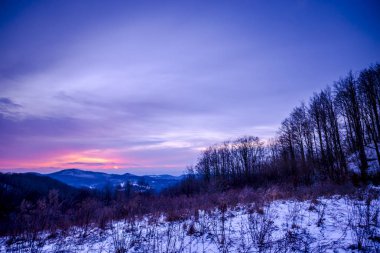 Alacakaranlıkta, menekşe kış manzarası inanılmaz karlı dağlar.