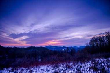 Alacakaranlıkta, menekşe kış manzarası inanılmaz karlı dağlar.