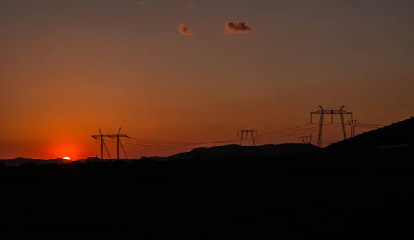 Strommasten Auf Feld Mit Orangefarbenem Sonnenuntergang — Stockfoto