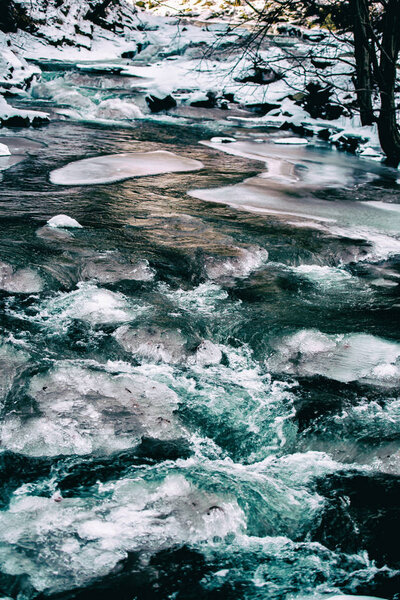 Winter river with melting ice crust