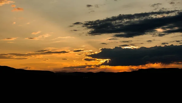 sunset sky with clouds and hills landscape on horizon
