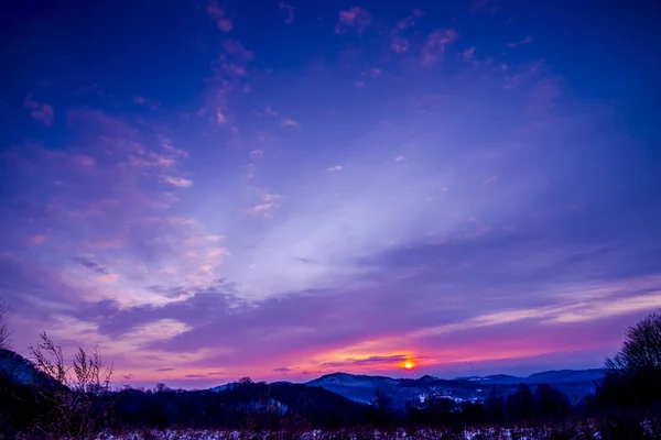 Alacakaranlıkta, menekşe kış manzarası inanılmaz karlı dağlar.