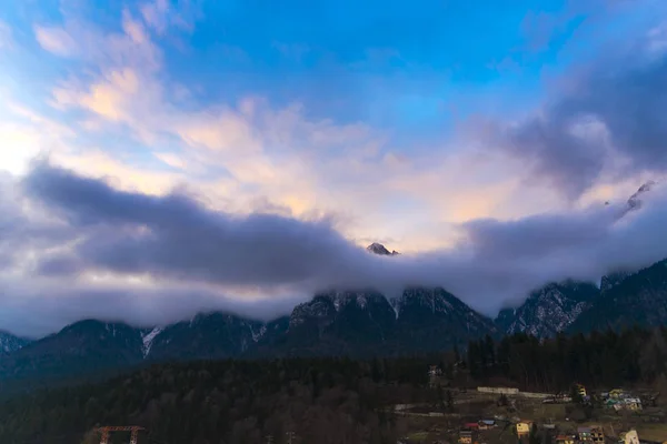 Clouds in scenic alpine mountains, purple sunset sky