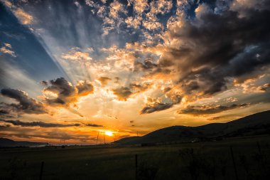 Çayır alacakaranlıkta. Renkli gökyüzü ve kabarık bulutlar günbatımı arka plan.
