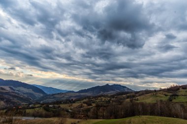 Bahar alanları Günbatımı ile bulutlu gökyüzü arka plan içinde çıplak ağaçlarıyla kaplı