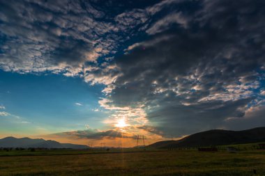 bulutlu akşam günbatımı, gökyüzü ve tepeler